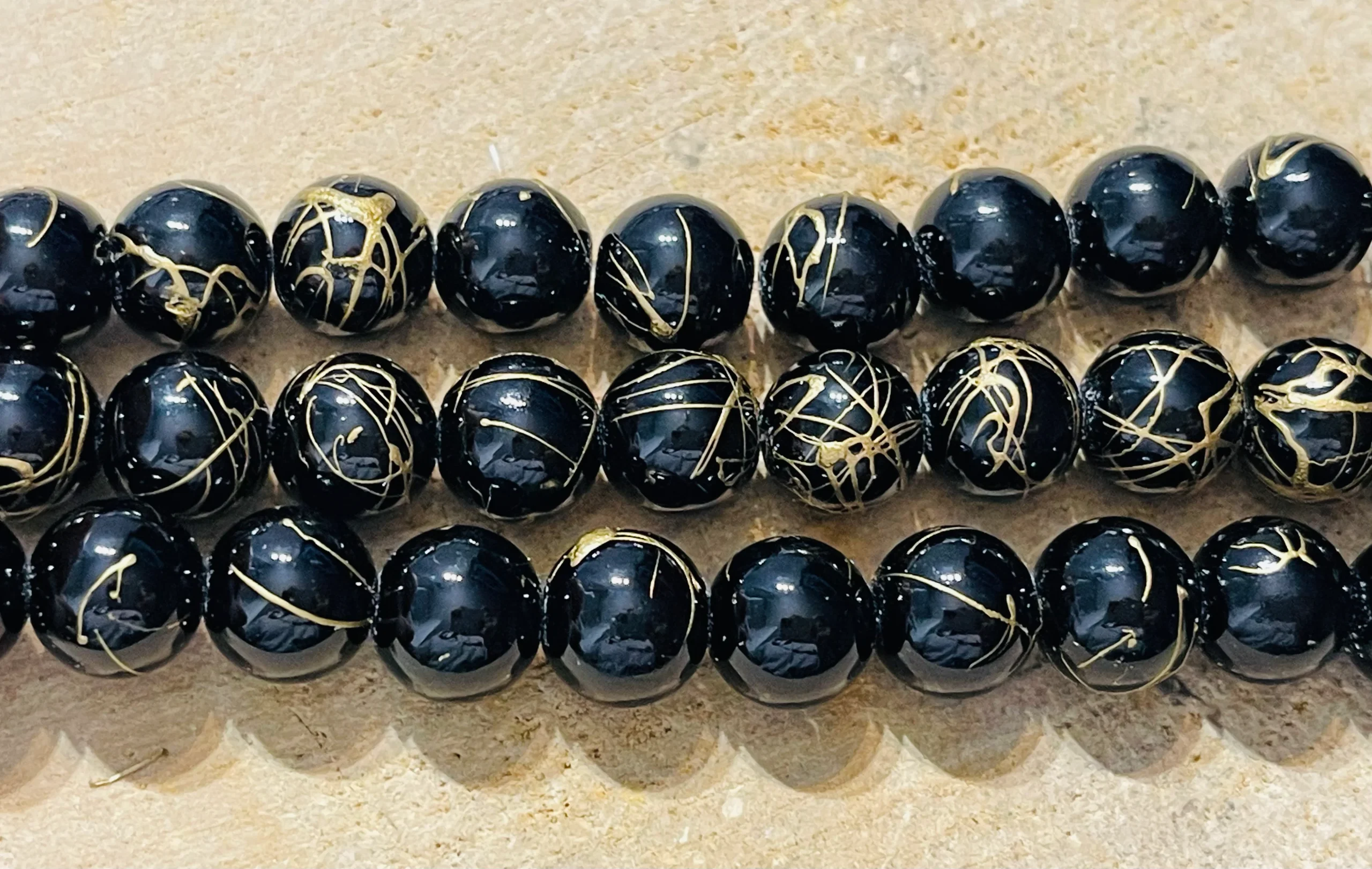 Perles en pierre naturelle en Onyx noir avec lignes dorées en 12 mm